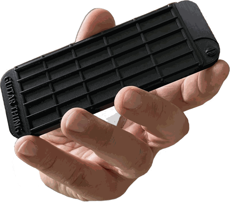 Hand holding a closed Guitar Thing, a black pocket-sized molded fretboard